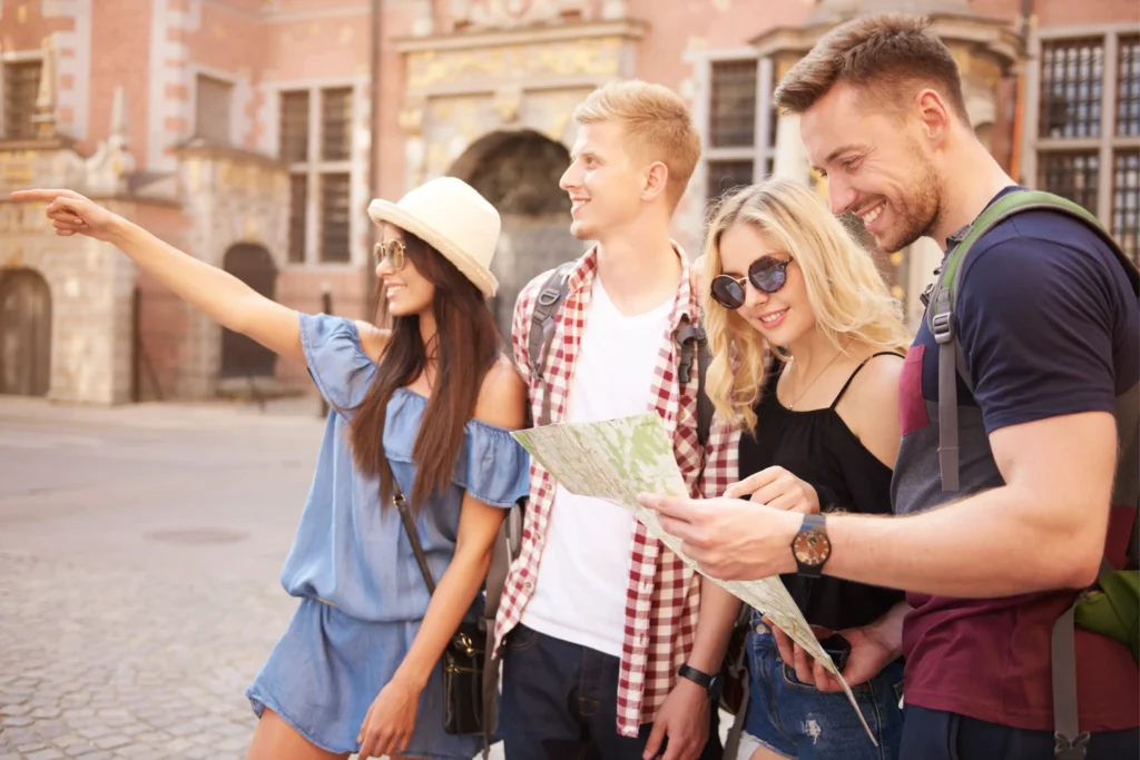 Group of tourists pointing directions and reading a map during a guided city tour