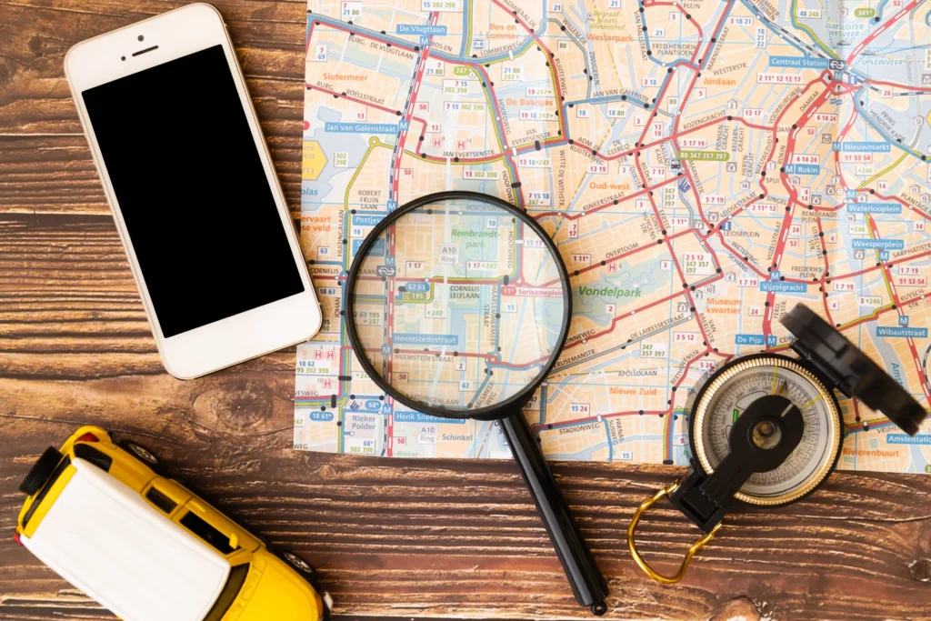 Smartphone, compass, and magnifying glass on a map — concept of local search optimization and travel visibility
