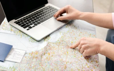 Woman using a laptop and map to plan a trip — symbolizing local SEO and travel planning for hotels and tour operators