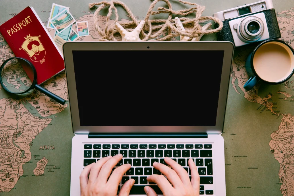 Travel content creation setup with laptop and global map for storytelling inspiration