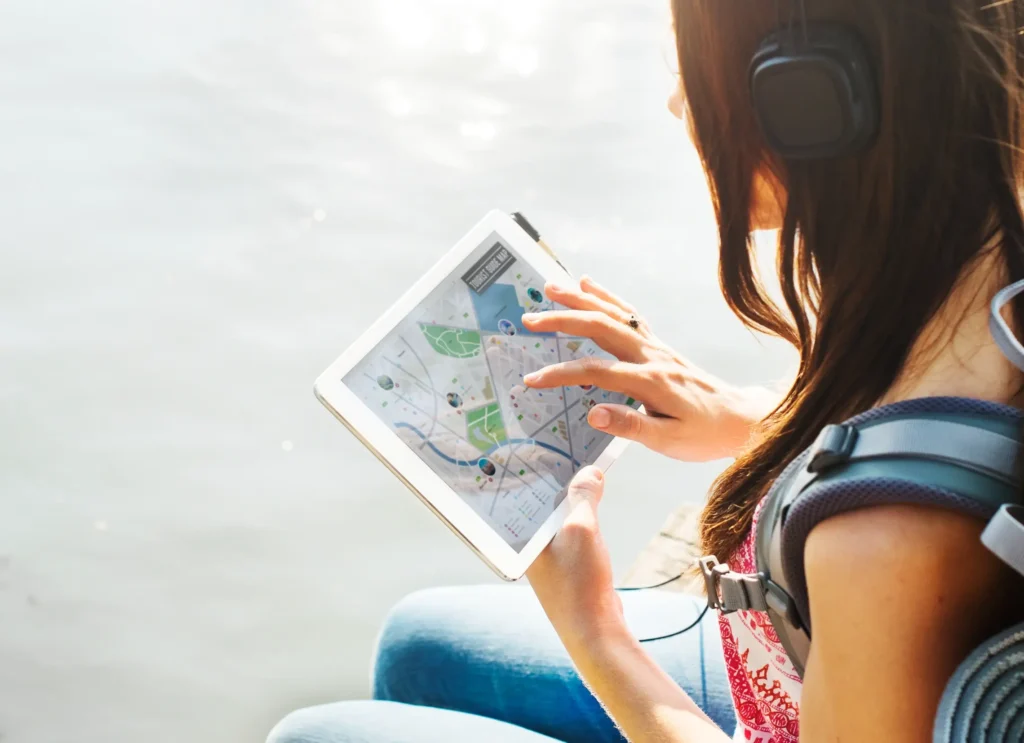 Traveler using AI-powered trip planning on a tablet to explore destinations and plan routes